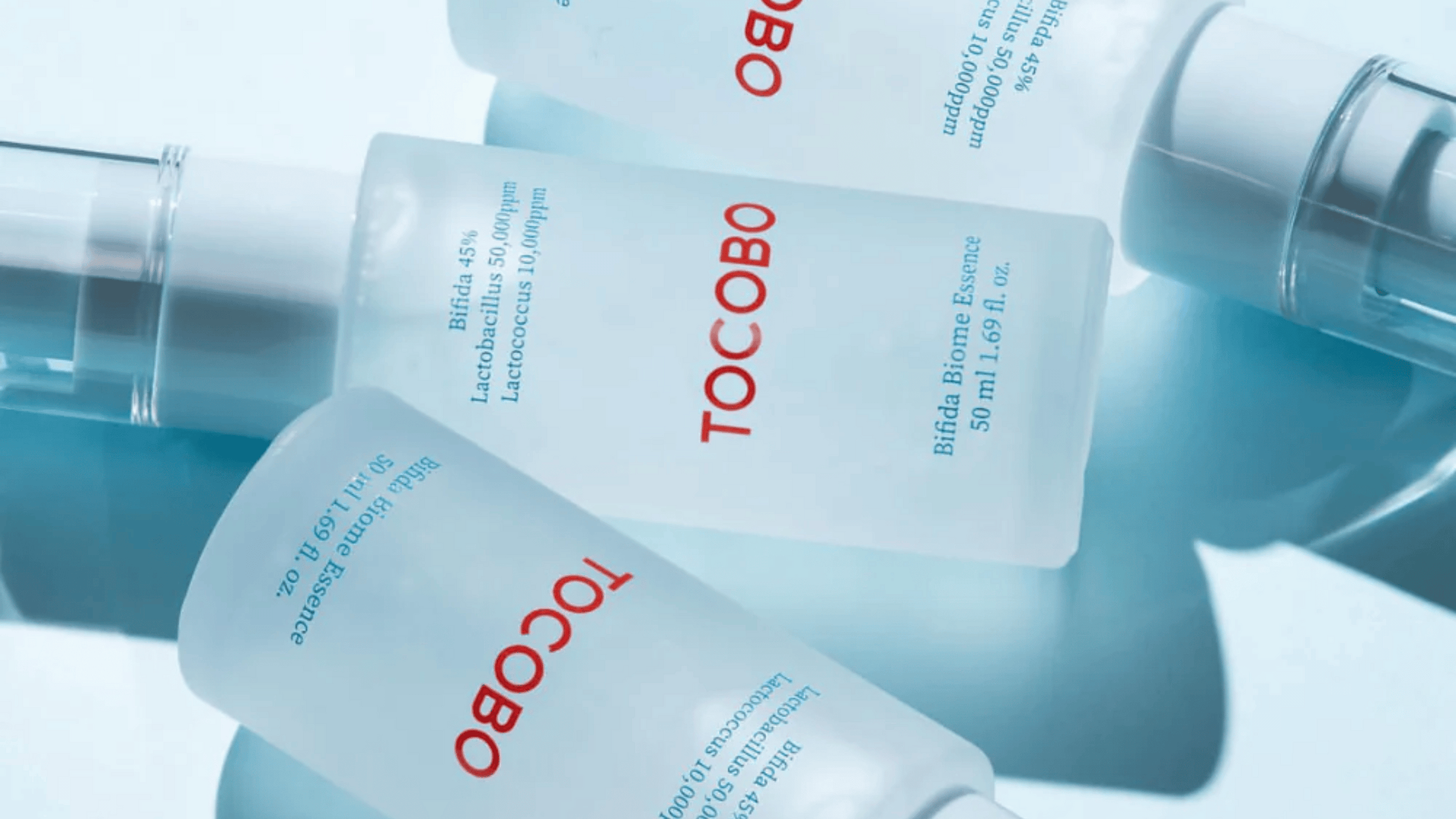 Tre flaskor TOCOBO-produkter på en blå yta.