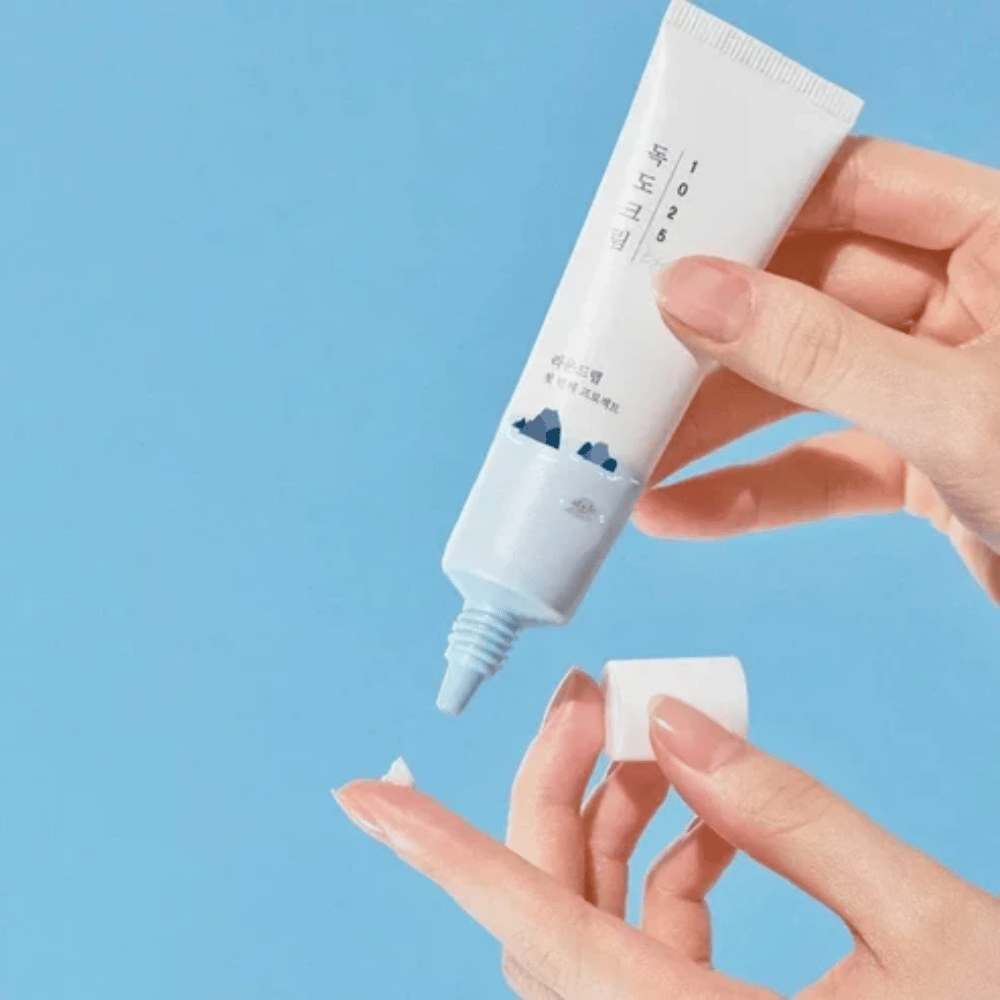 Round Lab 1025 Dokdo Eye Cream tube avec une crème légère appliquée sur le bout du doigt pour un soin doux de la peau sensible autour des yeux