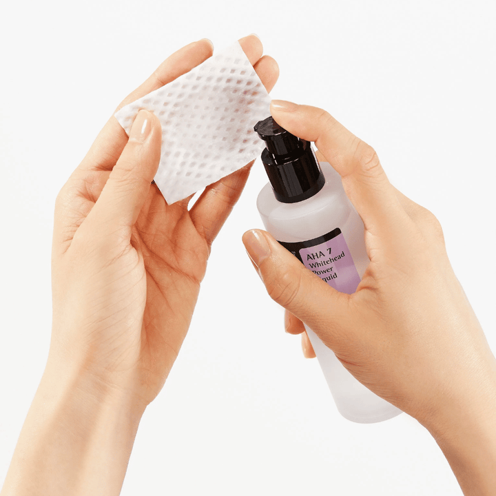 Application de COSRX AHA 7 Whitehead Power Liquid sur un coton, exfoliant toner visage avec AHA pour éliminer les cellules mortes de la peau et améliorer la texture de la peau.
