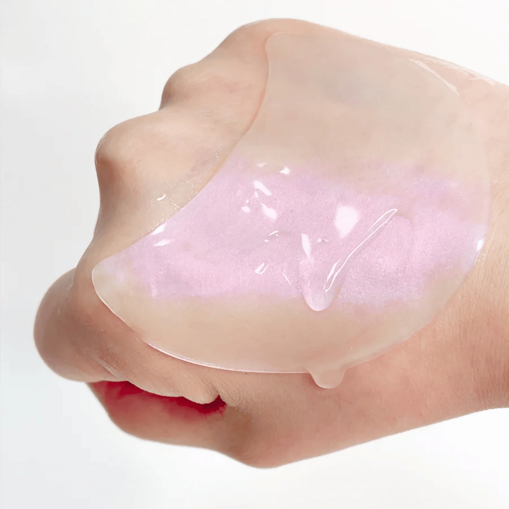 Patch pour les yeux en hydrogel rose avec rétinol montré sur une main, formule hydratante et illuminatrice.