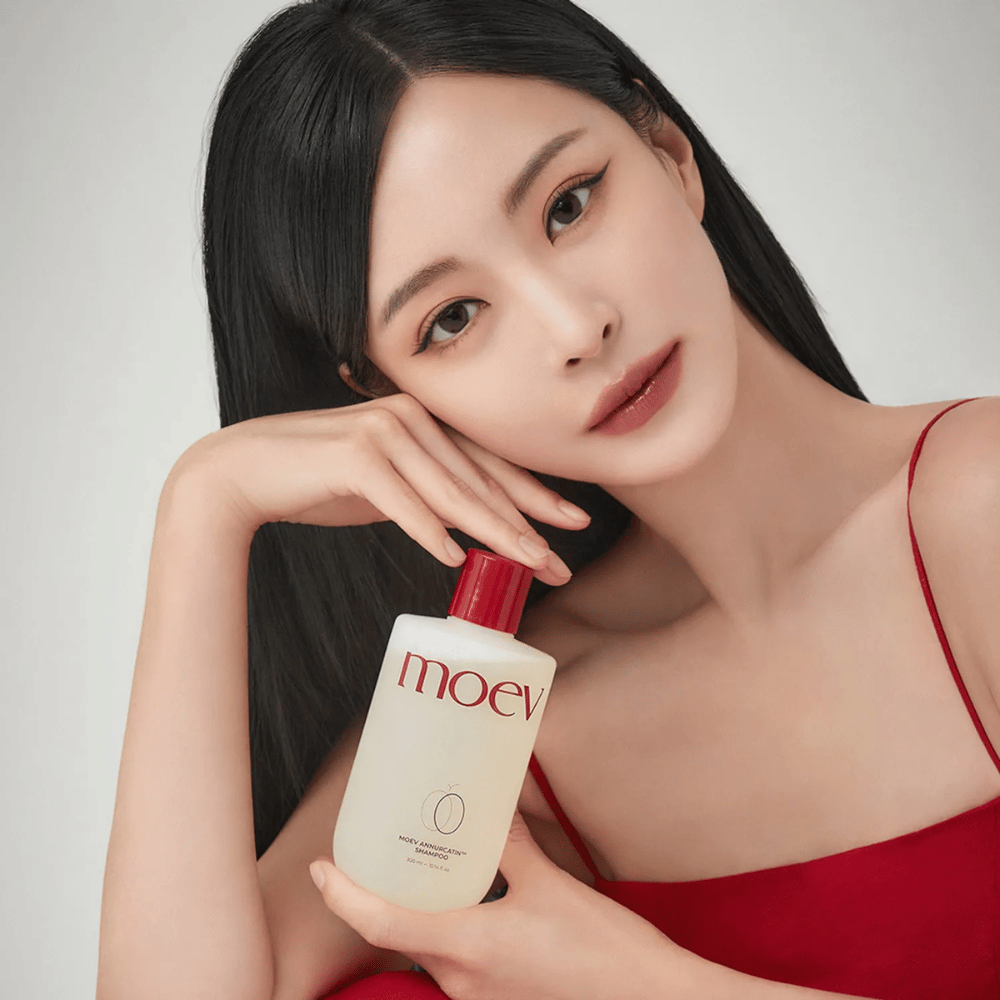 Femme aux cheveux longs et brillants tenant MOEV Annurcatin Shampoo – un shampooing coréen qui hydrate, renforce et protège les cheveux avec des ingrédients naturels.