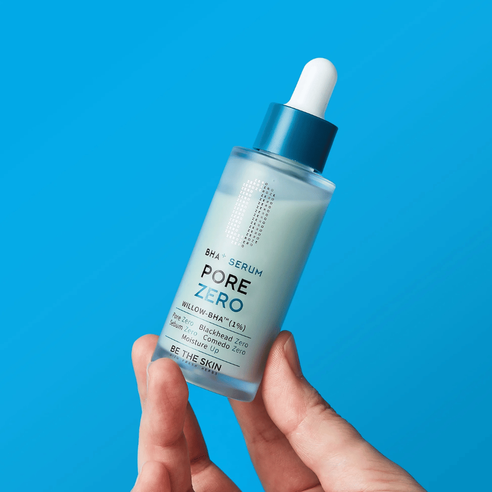 Be The Skin BHA+ Pore Zero Serum tenu dans la main sur fond bleu