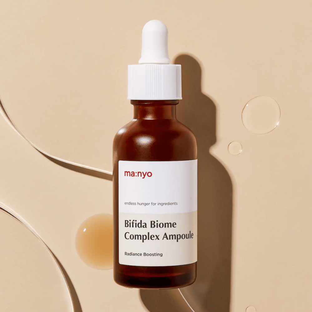 Image produit épurée de ma:nyo Bifida Biome Complex Ampoule mettant l’accent sur le design du flacon et des gouttes de sérum en arrière-plan.