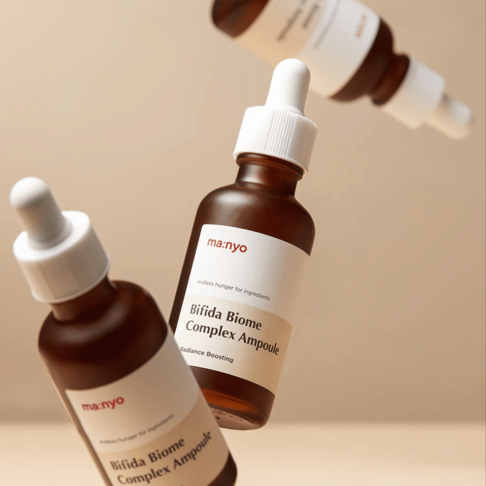 Image produit avec plusieurs flacons flottants de ma:nyo Bifida Biome Complex Ampoule sur fond beige, offrant une sensation moderne et minimaliste.