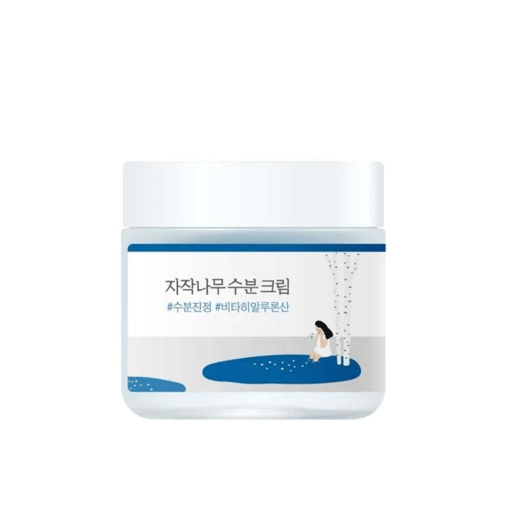 Round Lab Birch Juice Moisturizing Cream dans un pot transparent avec couvercle blanc et étiquette bleue avec illustration de bouleau et fille, découpé sur fond blanc.