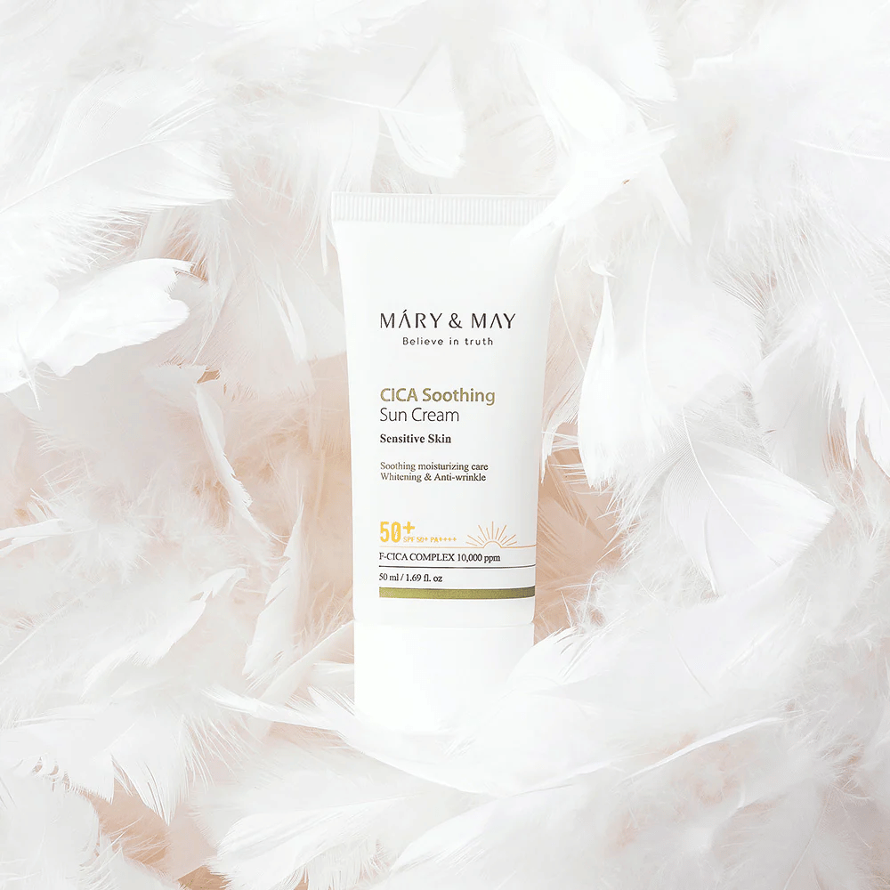 Mary&May CICA Soothing Sun Cream entouré de douces plumes blanches. L’image transmet une sensation de douceur, de confort et de formule légère adaptée aux peaux sensibles.