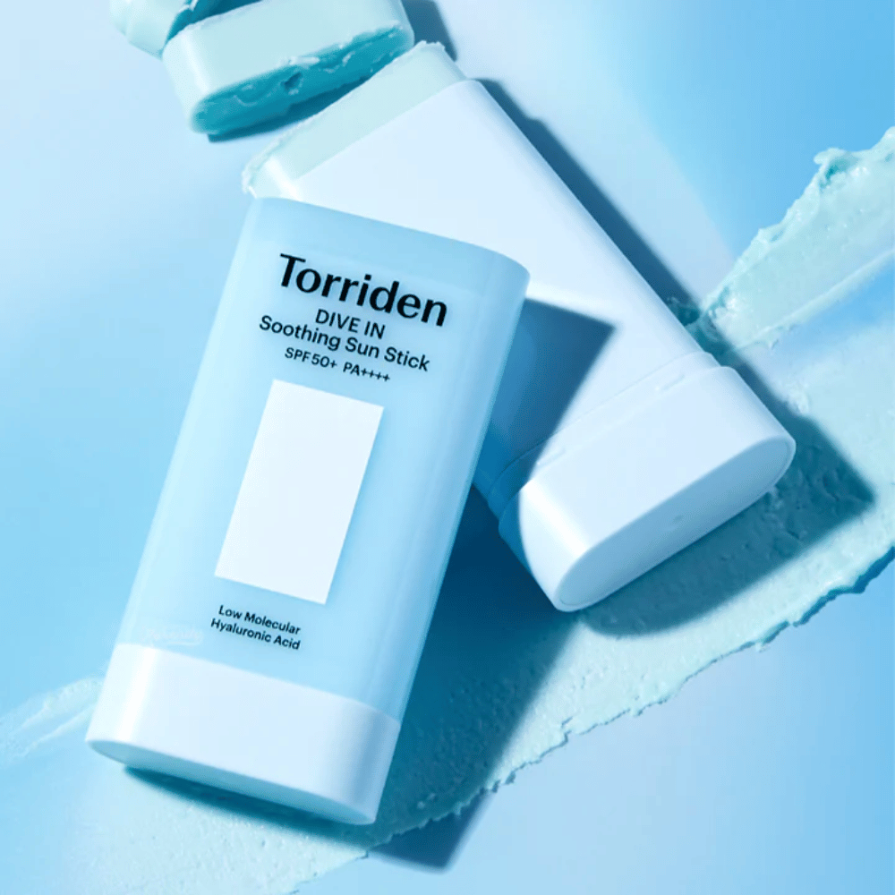 Torriden DIVE IN Soothing Sun Stick SPF50+ PA++++ avec une texture de produit étalée illustrant l’application légère et hydratante.