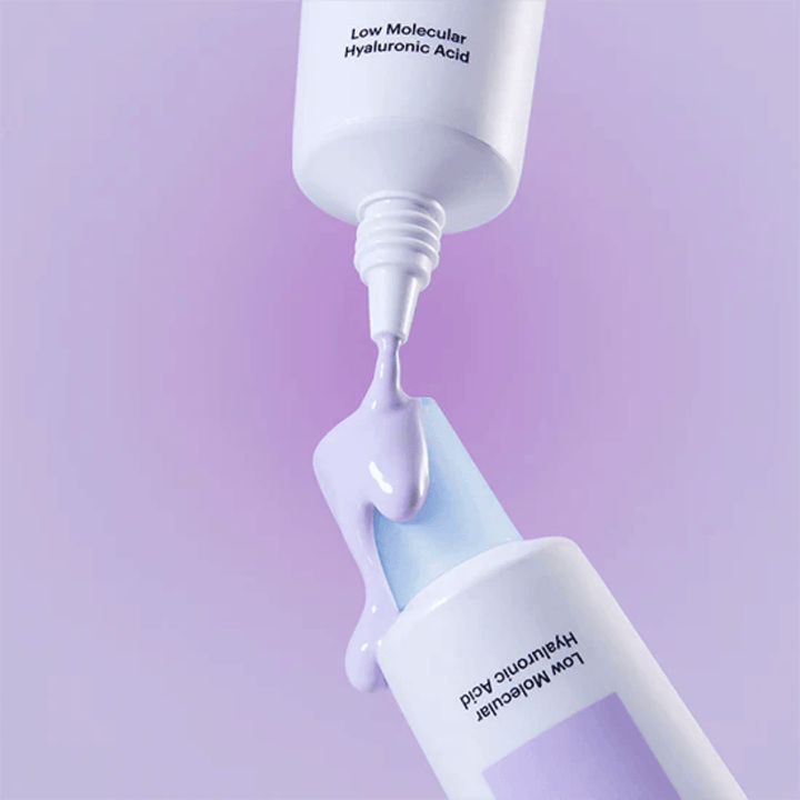 Gros plan sur Torriden DIVE IN Tone Up Sun Cream Purple où la crème violette est appliquée depuis le tube pour illustrer la consistance du produit.
