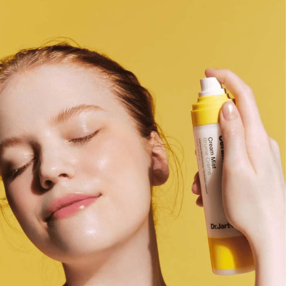 Une femme tient une bouteille Dr. Jart+ Ceramidin Cream Mist 110ml près du visage, mettant en avant ses avantages hydratants et sa formulation vegan.