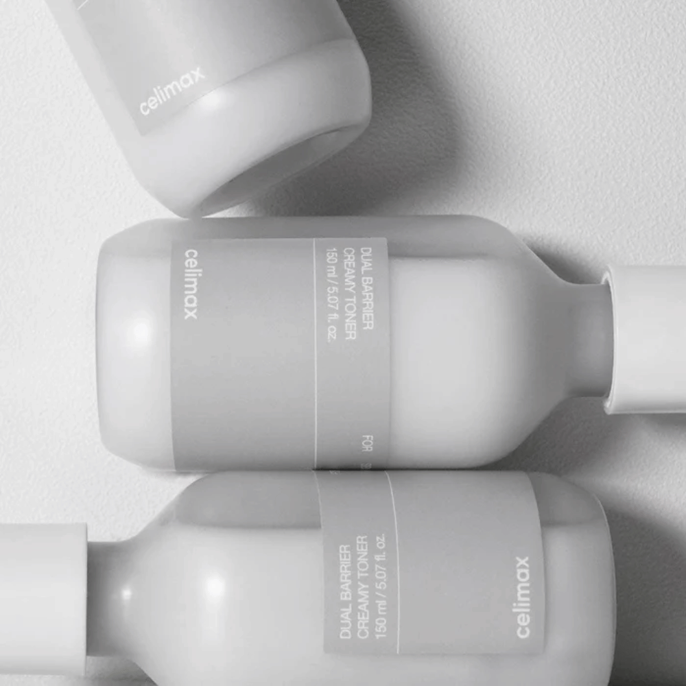 Trois bouteilles couchées de Celimax Dual Barrier Creamy Toner dans un design minimaliste avec étiquette grise et lumière douce – parfait pour les peaux sensibles et sèches.