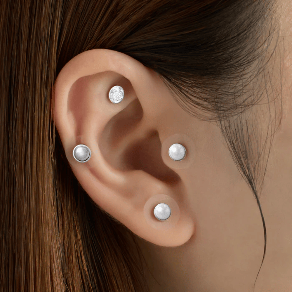 Gros plan sur une oreille avec plusieurs RETURNITY Ear Therapy Acupressure Patch appliqués sur différentes zones de l’oreille pour l’acupression et un look épuré.