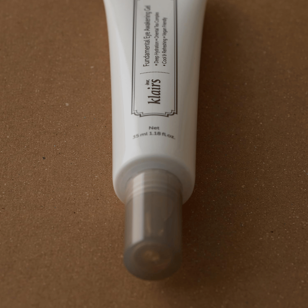 Gros plan sur le capuchon transparent du tube et sa partie inférieure. L’image met en avant le design épuré de l’emballage ainsi que l’applicateur hygiénique qui protège le produit entre les utilisations.