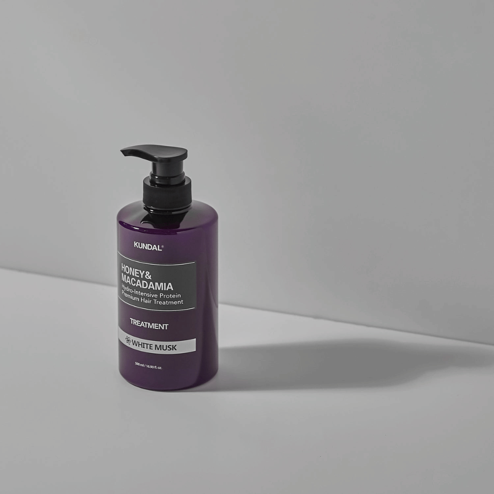 KUNDAL Honey & Macadamia Hydro-Intensive Protein Premium Hair Treatment White Musk dans un flacon pompe violet, 500 ml.