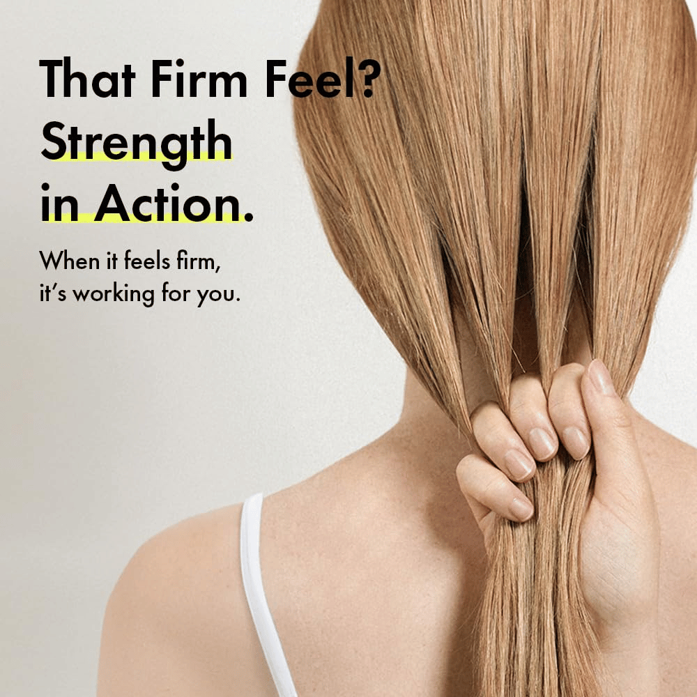 Une personne tient ses cheveux pour illustrer des fibres capillaires plus fortes et une sensation de cheveux plus fermes après l’utilisation de Grabity g0.0 Hair Lifting Shampoo Strong.