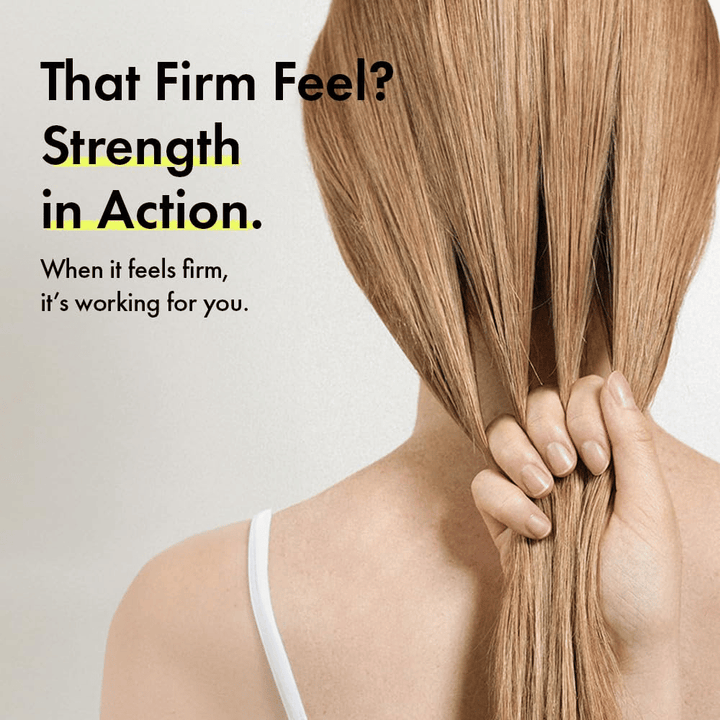 Une personne tient ses cheveux pour illustrer des fibres capillaires plus fortes et une sensation de cheveux plus fermes après l’utilisation de Grabity g0.0 Hair Lifting Shampoo Strong.