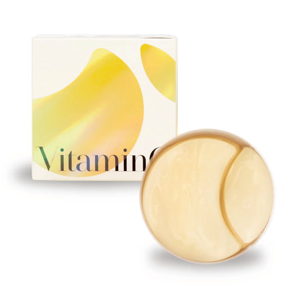 K-Secret Extra Illuminating Eye Gel Patches avec vitamine C en hydrogel scintillant doré, pot et emballage en arrière-plan.