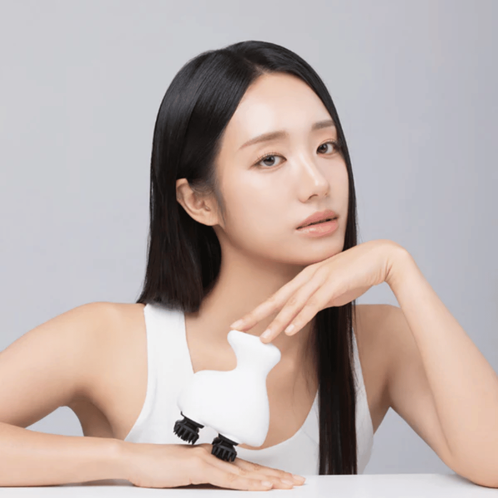 Le modèle pose avec Beaund Lift Head Spa et met en valeur son design ergonomique. L’image présente le produit comme un outil de massage du cuir chevelu et de soin relaxant.