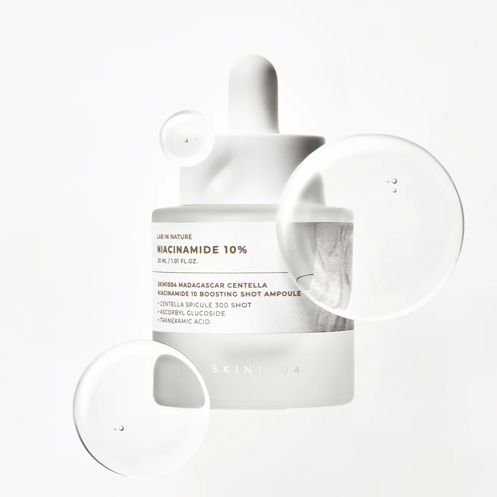 SKIN1004 Madagascar Centella Niacinamide 10 Boosting Shot Ampoule avec des gouttes de sérum montrant une formule légère, rapidement absorbée avec niacinamide, acide tranexamique et centella.