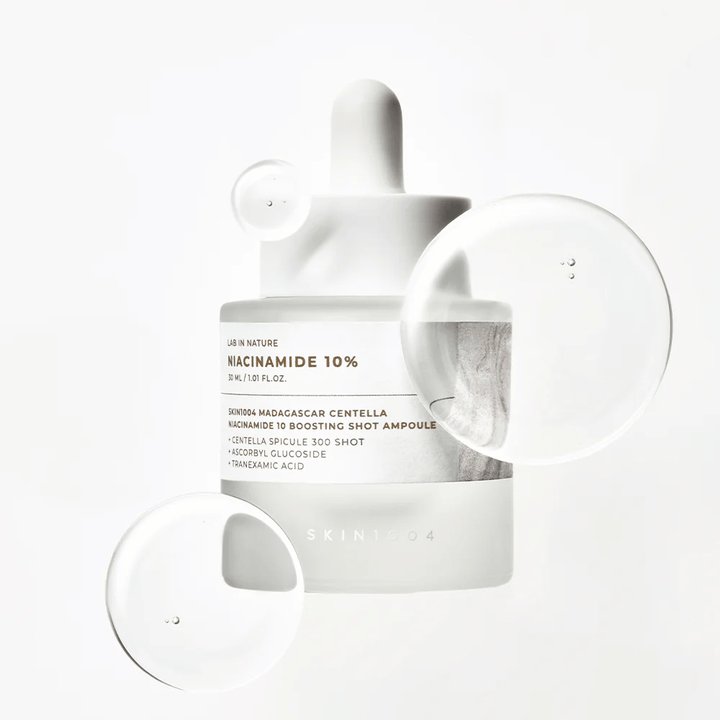 SKIN1004 Madagascar Centella Niacinamide 10 Boosting Shot Ampoule avec des gouttes de sérum montrant une formule légère, rapidement absorbée avec niacinamide, acide tranexamique et centella.