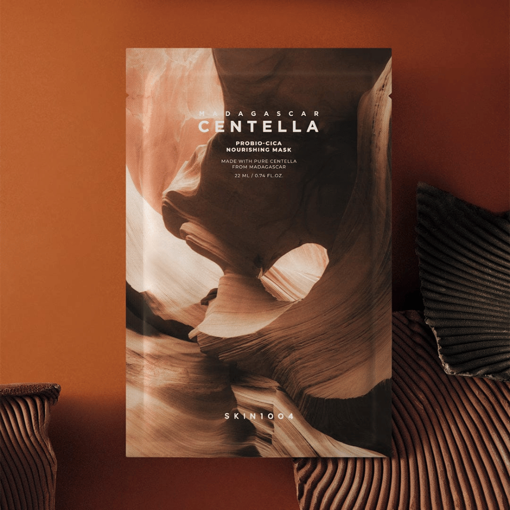 Emballage de Sheet mask de SKIN1004 sur fond brun chaud avec un design inspiré de la nature.
