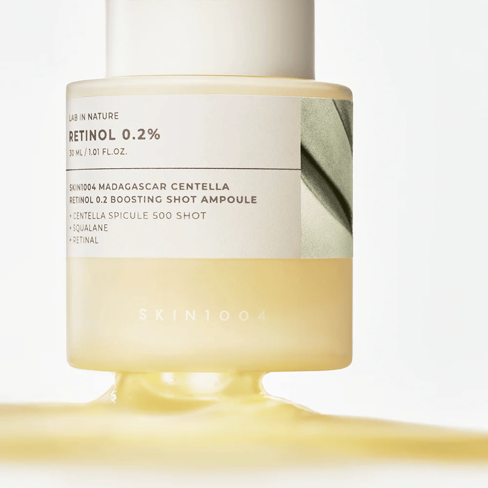 Gros plan sur SKIN1004 Madagascar Centella Retinol 0.2 Boosting Shot Ampoule montrant la consistance jaune pâle et soyeuse du sérum rétinol pour le renouvellement nocturne de la peau.