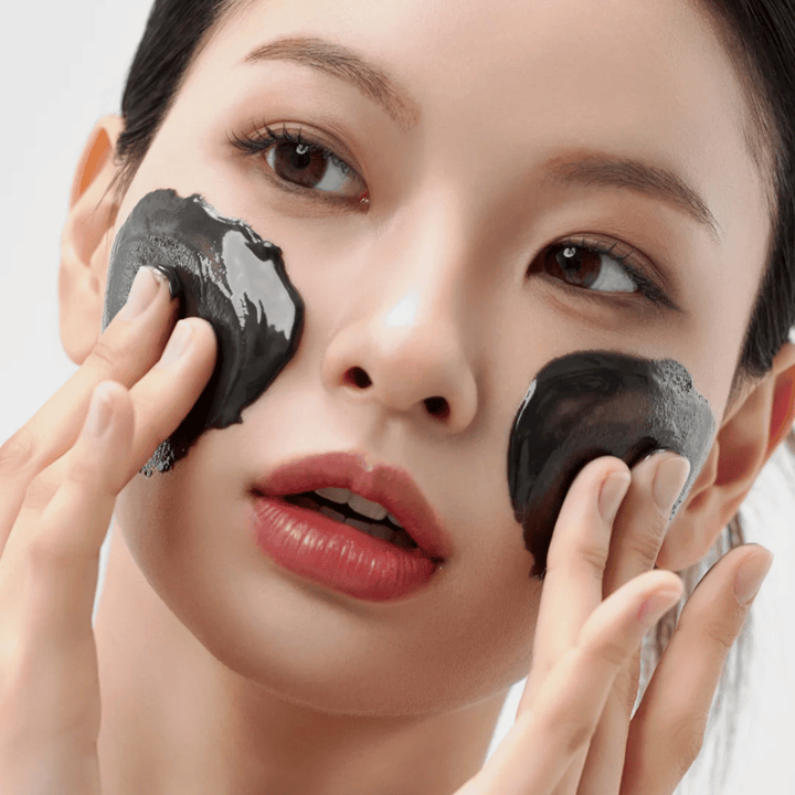 Gros plan sur l'application de Comment Midnight Soothing Cleansing Balm sur le visage. Baume nettoyant doux qui dissout les impuretés et procure une sensation de peau apaisée.