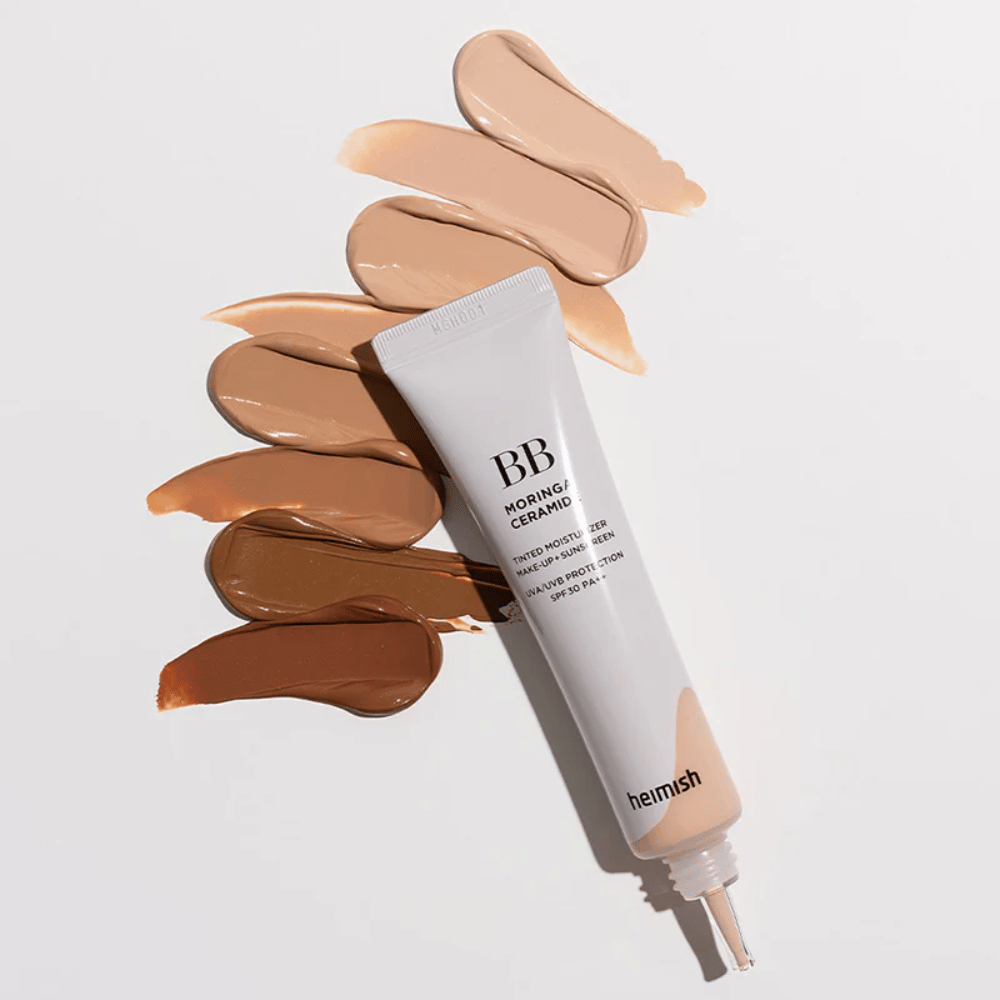 Heimish Moringa Ceramide BB Cream entouré de plusieurs échantillons de teinte dans différents tons de peau. L’image montre la large gamme de couleurs du produit et la texture crémeuse qui offre une couvrance naturelle et un teint uniforme.