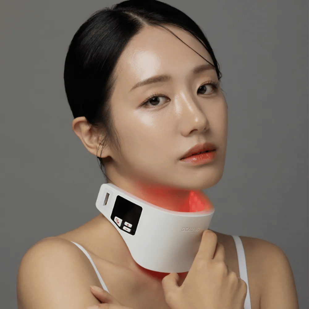 Le modèle utilise Beaund Neckcera autour du cou. L’éclairage LED rouge illustre le traitement actif tandis que l’appareil repose confortablement contre la peau.