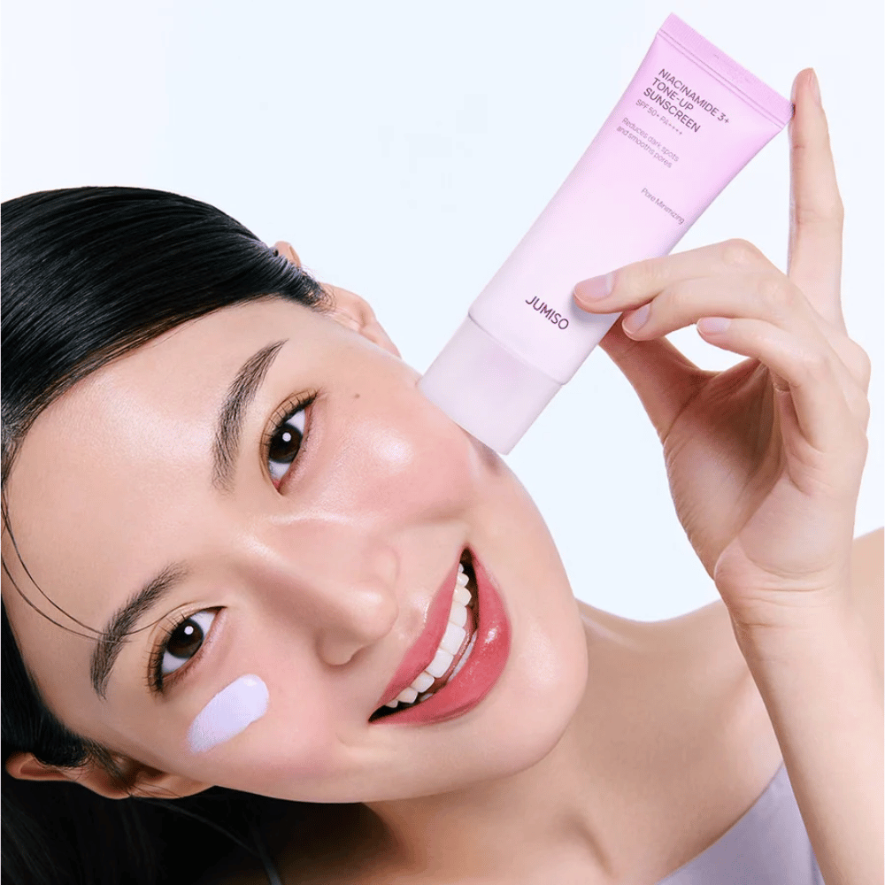 Le modèle applique JUMISO Niacinamide 3+ Tone-Up Sunscreen SPF50+ PA++++ pour une protection UV, un teint plus uniforme et un éclat naturel.