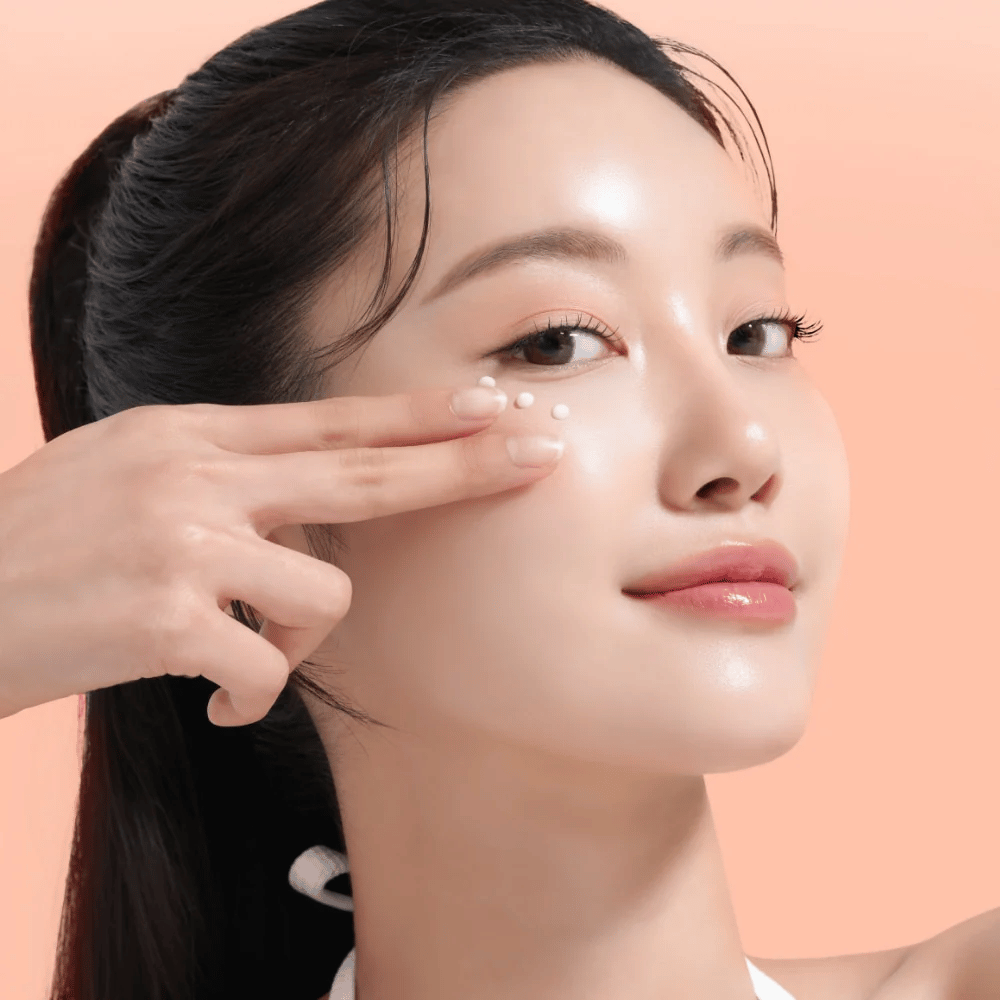 Une personne applique Mixsoon PDRN Collagen Eye Serum sous les yeux. Le sérum illumine, réduit les gonflements et renforce la fermeté de la peau.