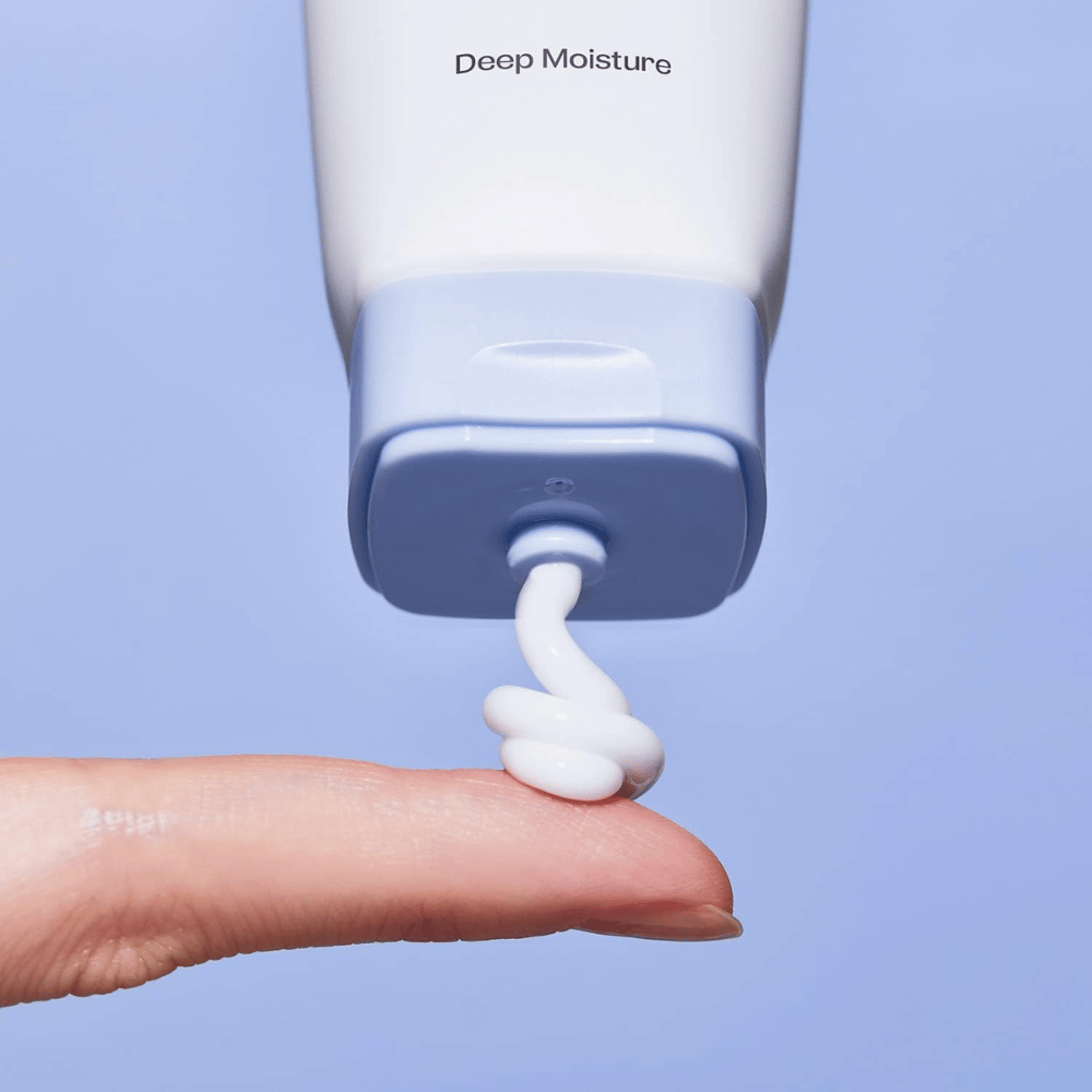 1. Ma:nyo Panthetoin Cream – gros plan sur un crème visage hydratant blanc appliqué depuis un tube bleu clair sur un doigt