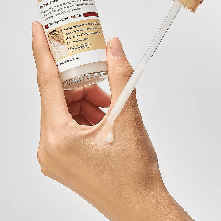 Gros plan sur Dr.Melaxin Peel Shot Rice Ampoule appliqué avec pipette sur la main, ampoule exfoliante légère qui s'absorbe rapidement et donne une peau hydratée et lisse.