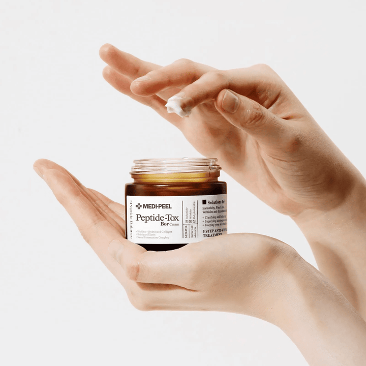 Application de MEDI-PEEL Peptide-Tox Bor Cream – crème visage coréen avec des peptides qui améliorent l'élasticité de la peau, procurent une hydratation profonde et aident à réduire les rides.