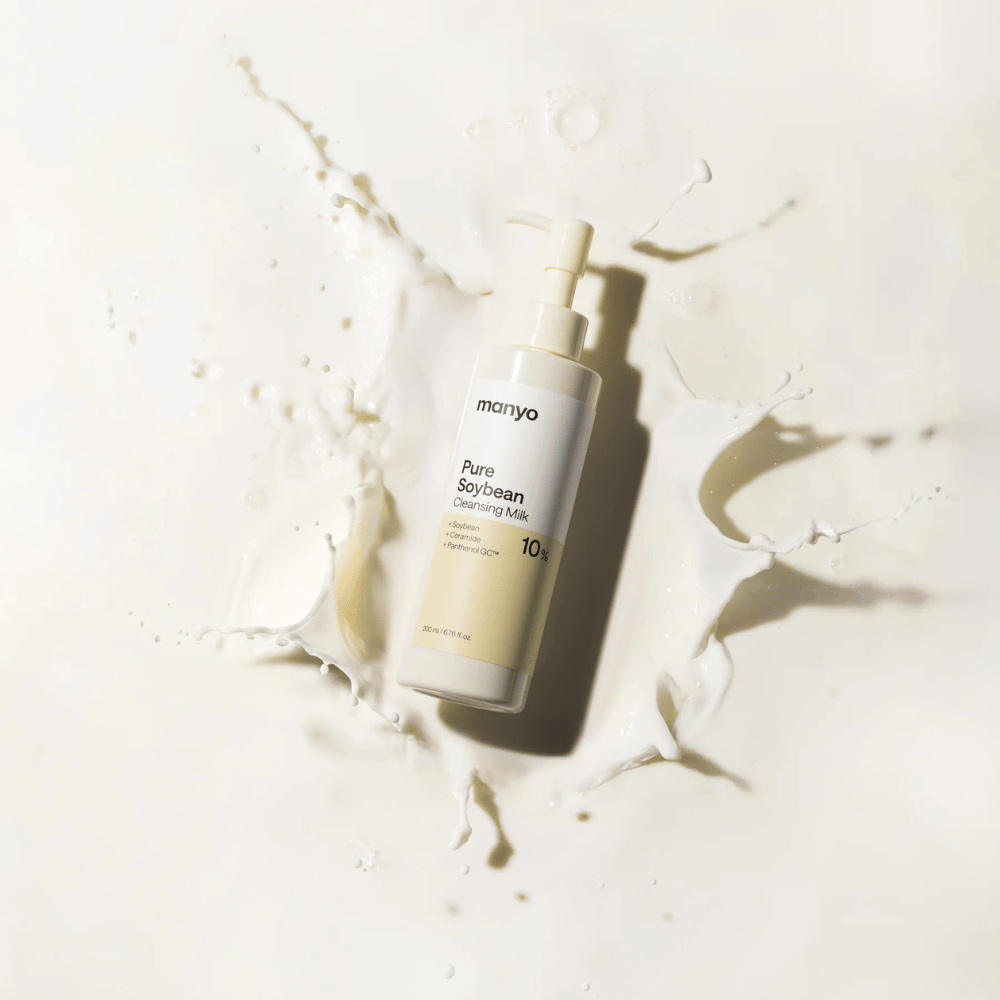 1. Ma:nyo Pure Soybean Cleansing Milk – lait nettoyant doux au soja dans un flacon pompe entouré d’éclaboussures de lait sur fond clair