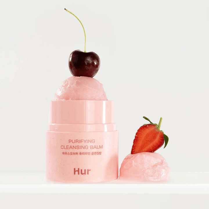 Ouvert Comment Purifying Cleansing Balm avec texture semblable à un sorbet décorée de cerises et de fraises. Baume nettoyant inspiré des fruits avec des propriétés adoucissantes et nettoyantes.