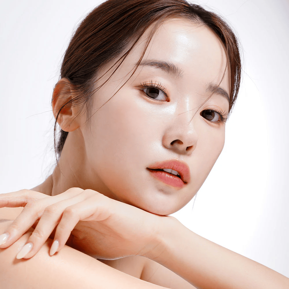 Gros plan d'une femme avec une peau éclatante et hydratée. Sa beauté naturelle est mise en valeur par un éclairage doux, donnant un aspect frais et sain.