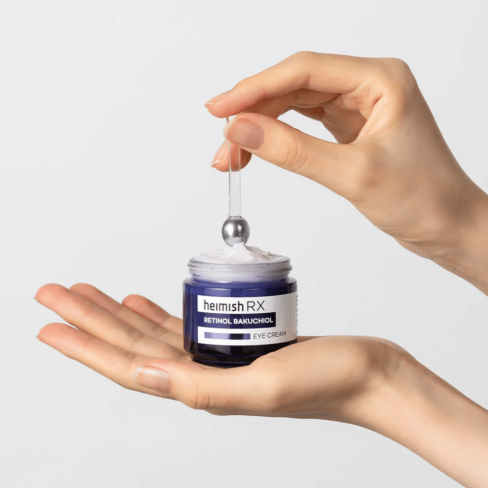 Heimish RX Retinol Bakuchiol Eye Cream dans un pot bleu élégant, soulevé avec un applicateur métallique. Une crème pour les yeux avec rétinol et bakuchiol pour réduire les rides fines et donner une peau plus ferme.