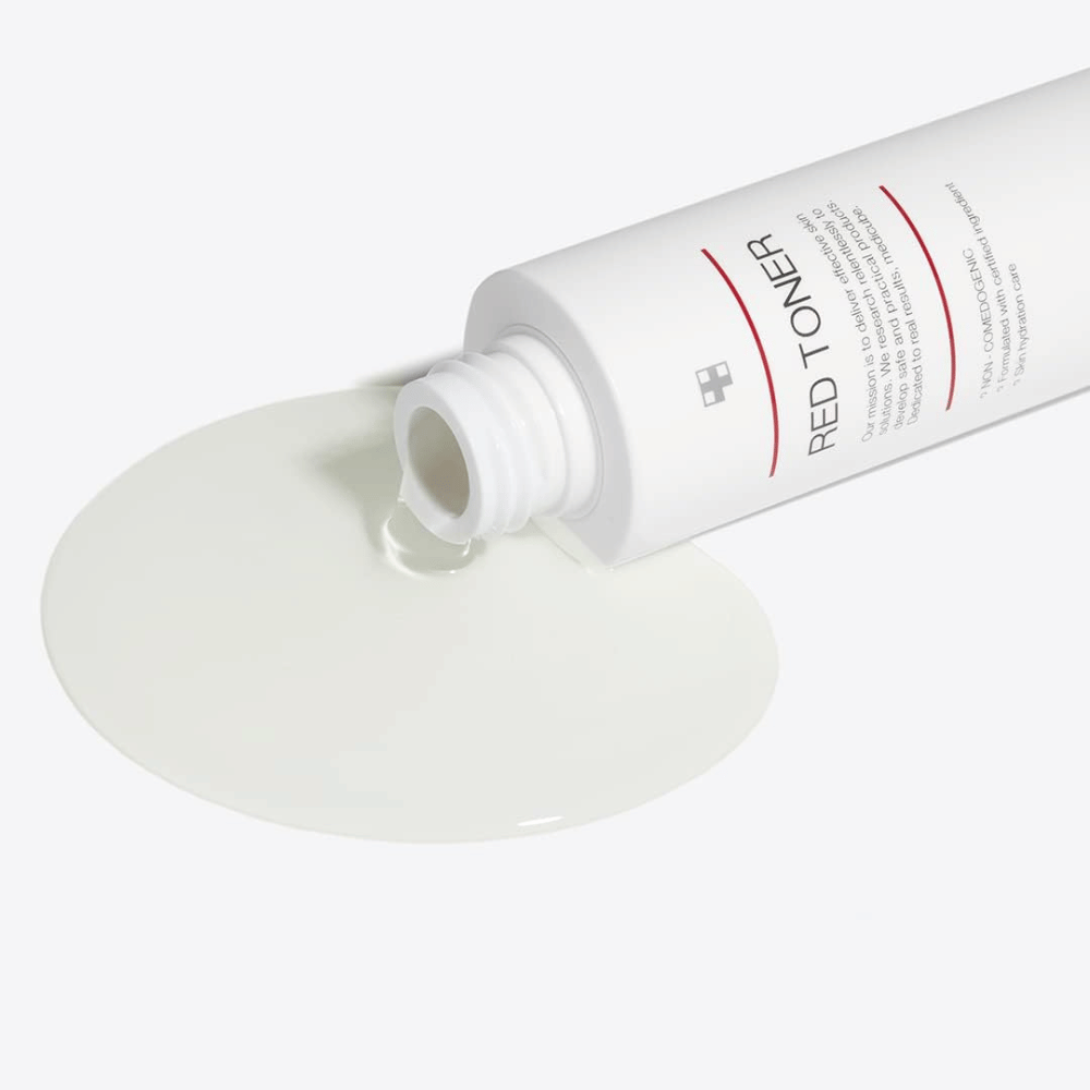 Bouteille ouverte avec medicube Red Toner versée sur une surface blanche – montre la consistance légère et fluide du produit.
