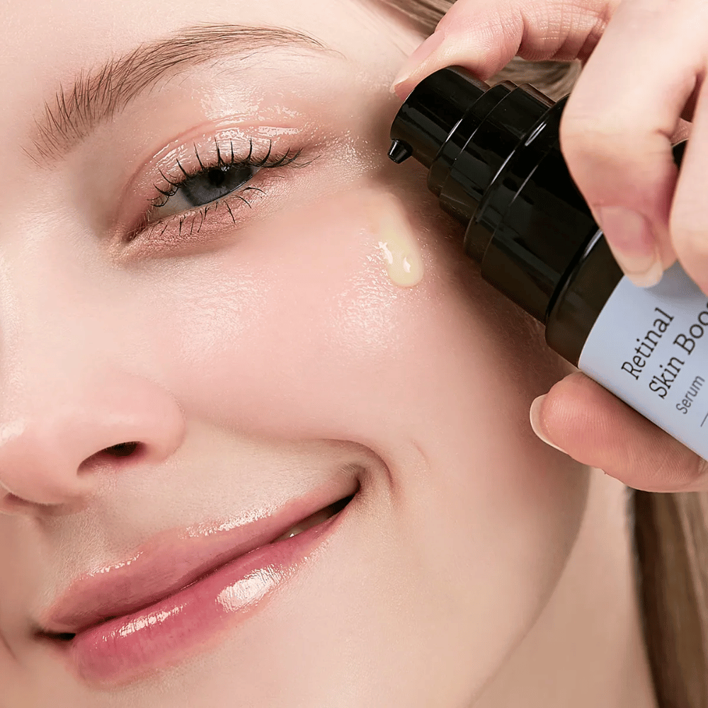 Une personne applique Meditherapy Retinal Skin Booster Serum près de l'œil. Le sérum a une légère teinte jaune et donne à la peau éclat et fermeté.
