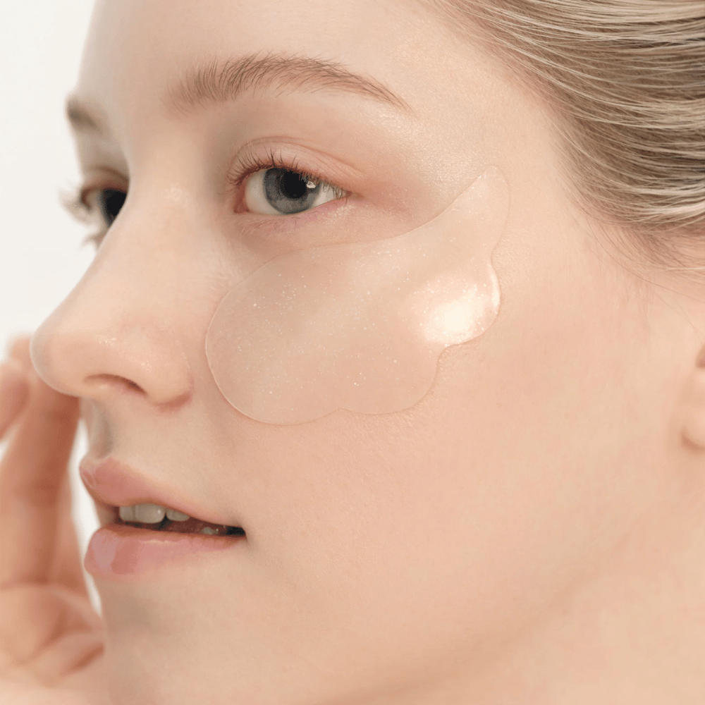 Gros plan sur un modèle appliquant Beauty of Joseon patch pour les yeux sous l'œil pour l'hydratation, l'éclat et l'effet raffermissant.