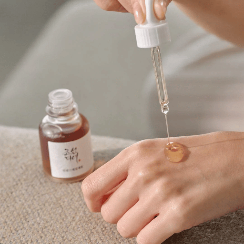Pipette dépose des gouttes de Beauty of Joseon Revive Serum Ginseng + Snail Mucin sur la peau – sérum coréen pour l'élasticité et l'hydratation.