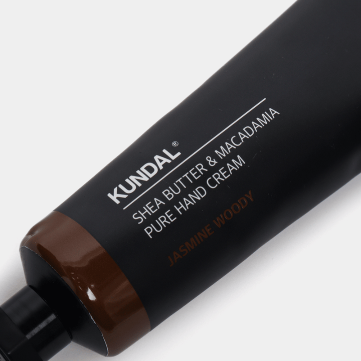 Gros plan sur KUNDAL Shea Butter & Macadamia Pure Hand Cream Jasmine Woody montrant l'emballage élégant et la sensation premium de la crème pour les mains.