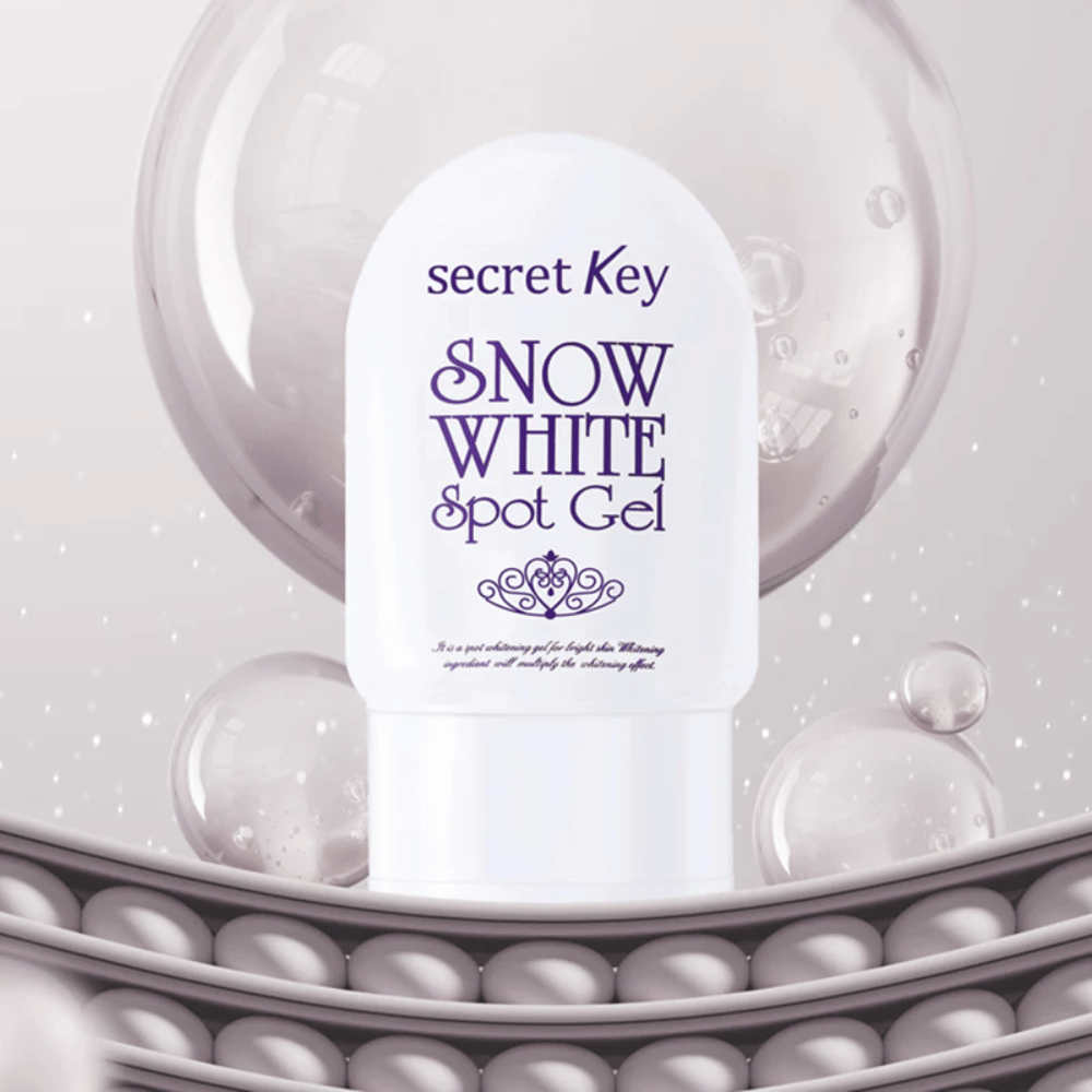 Secret Key Snow White Spot Gel dans un emballage blanc sur fond avec des bulles et des détails ressemblant à des perles.