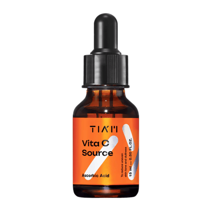TIA'M Vita C Source, ett serum med askorbinsyra i brun glasflaska med svart pipett och orange etikett – effektiv för att ljusa upp huden och minska ojämn hudton.