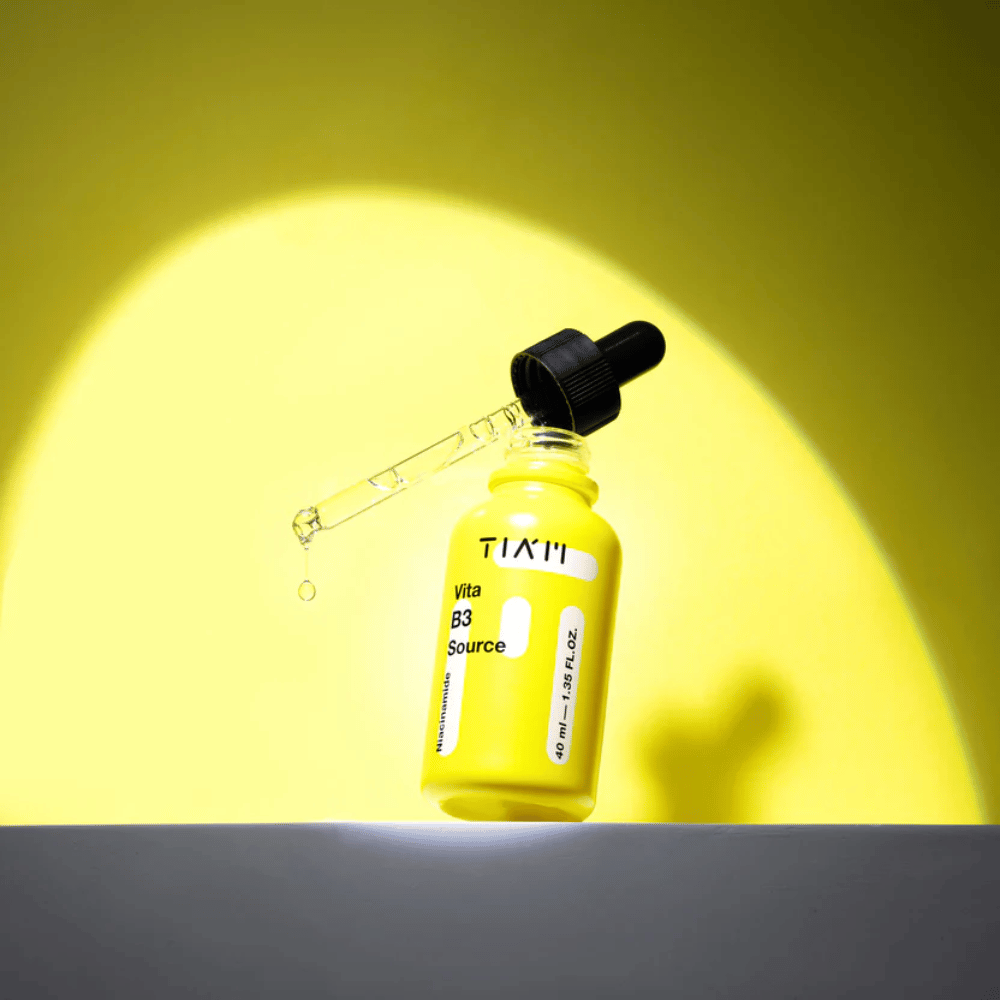 TIA'M Vita B3 Source – sérum à la niacinamide dans un flacon jaune avec pipette, conçu pour éclaircir la peau et donner un teint plus clair.