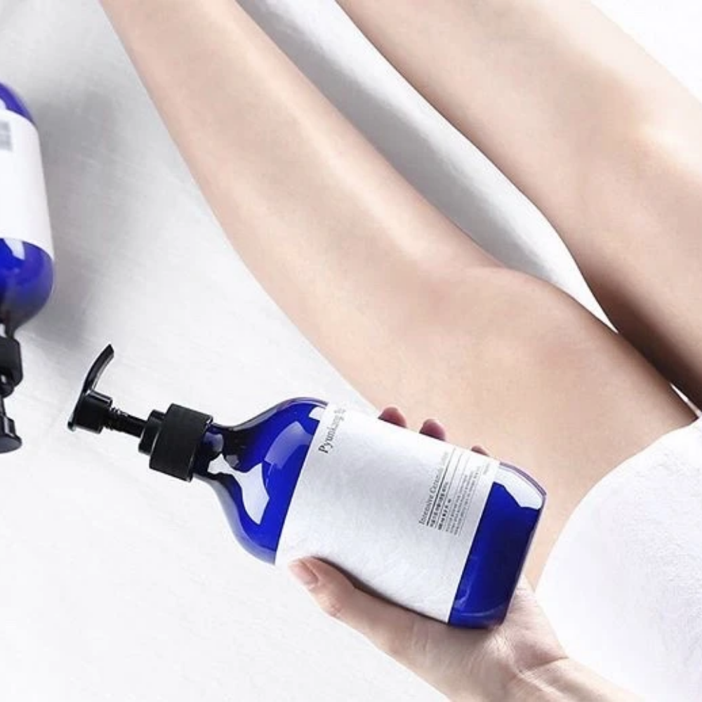 Une femme tenant une bouteille Pyunkang Yul Intensive Ceramide Lotion 500ml à côté de ses jambes.